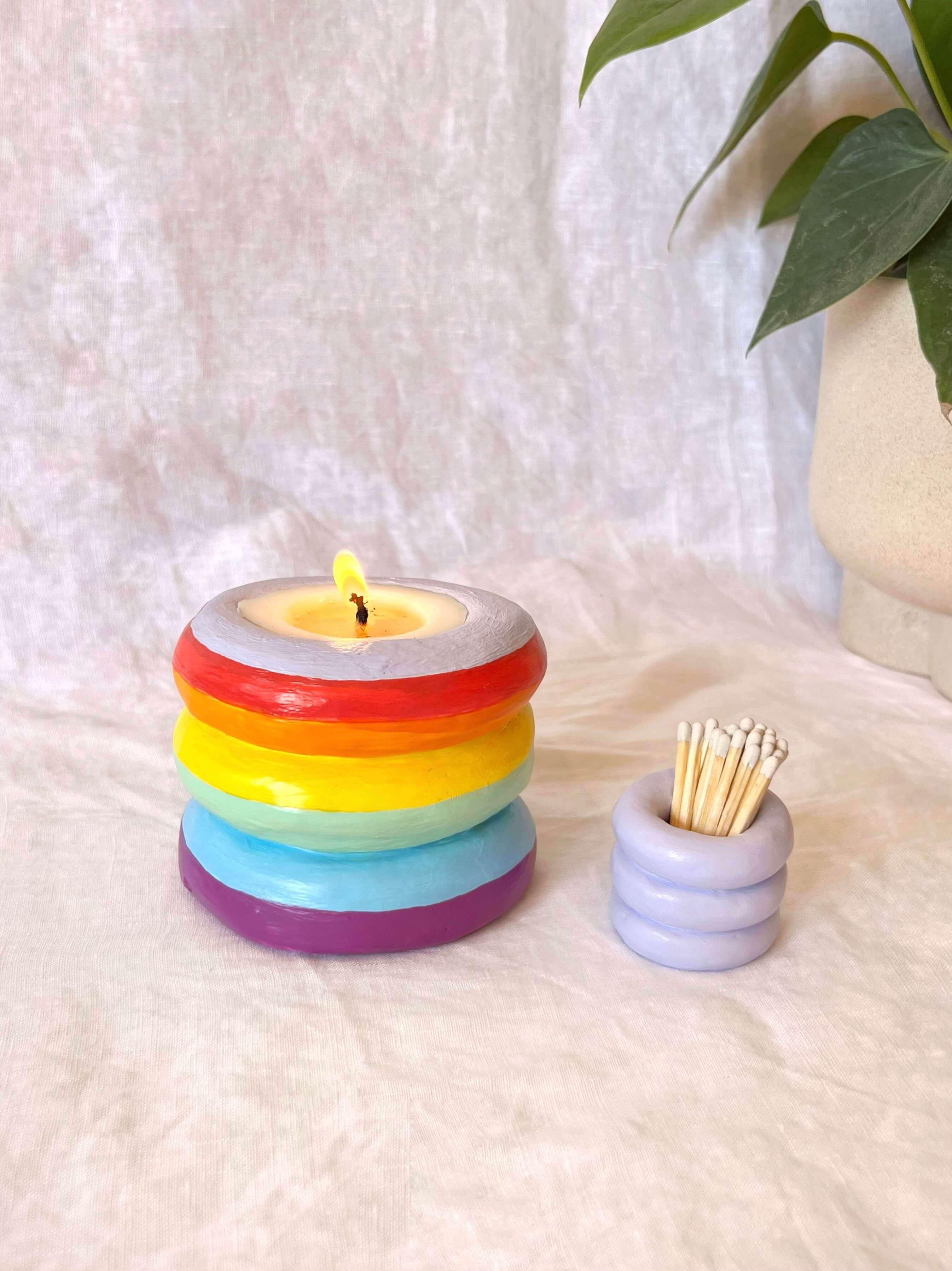 Layered rainbow candle in clear container