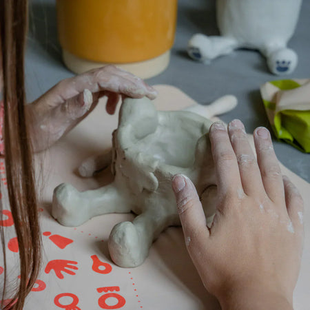 Une jeune enfant sculptant un joli projet DIY avec son kit de poterie Sculpd pour enfants