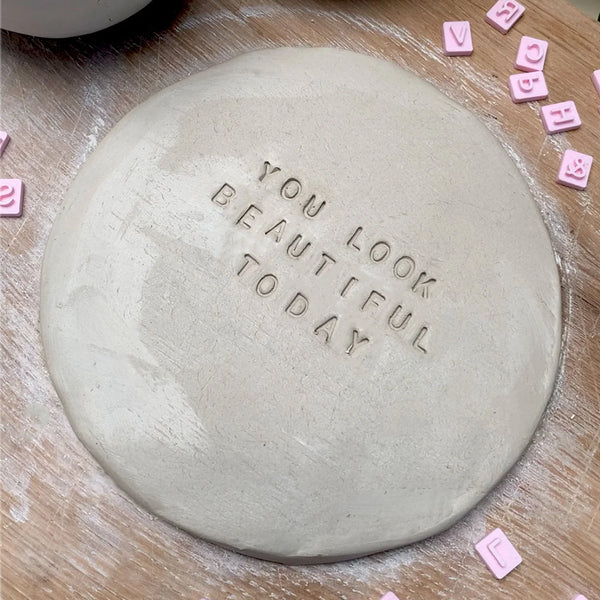 Sculpd letter stamp in wet clay